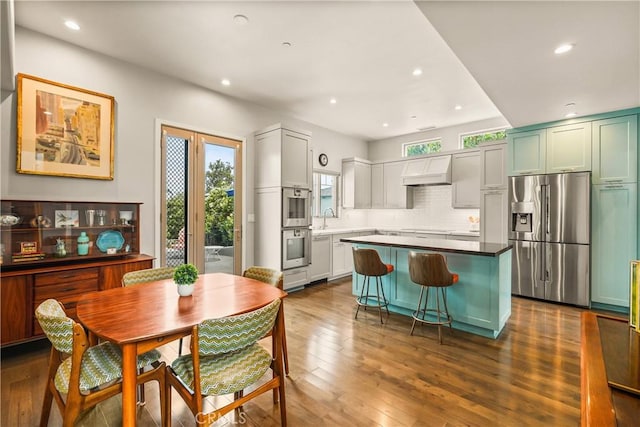 6557 Clybourn Ave, North Hollywood, CA 91606 - kitchen featuring appliances with stainless steel finishes, premium range hood, tasteful backsplash, recessed lighting, and a kitchen island