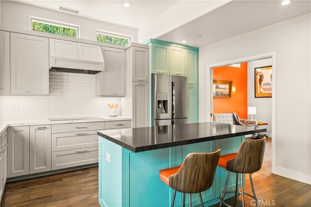 6557 Clybourn Ave, North Hollywood, CA 91606 - kitchen featuring stainless steel refrigerator with ice dispenser, electric cooktop, dark wood-style floors, a breakfast bar area, and recessed lighting