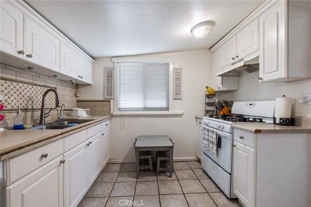 435 S Palm Ave, Santa Paula, CA 93060 - kitchen featuring white range with gas cooktop, under cabinet range hood, backsplash, and white cabinets