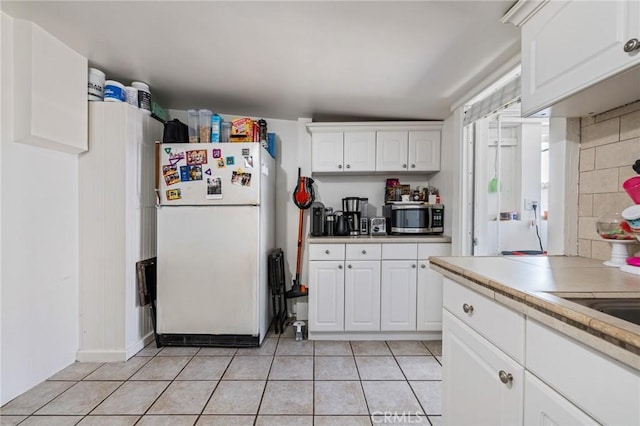 435 S Palm Ave, Santa Paula, CA 93060 - kitchen featuring freestanding refrigerator, stainless steel microwave, white cabinetry, and light tile patterned flooring