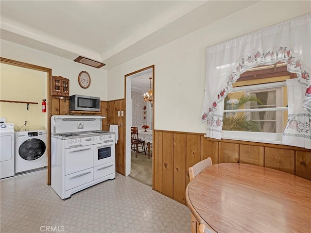 2345 22nd St, Santa Monica, CA 90405 - kitchen featuring stainless steel microwave, double oven range, washing machine and clothes dryer, wainscoting, and a chandelier