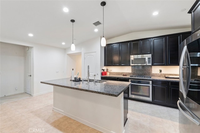 29184 Tree House, Lake Elsinore, CA 92530 - kitchen featuring stainless steel appliances, dark stone countertops, vaulted ceiling, dark cabinets, and backsplash