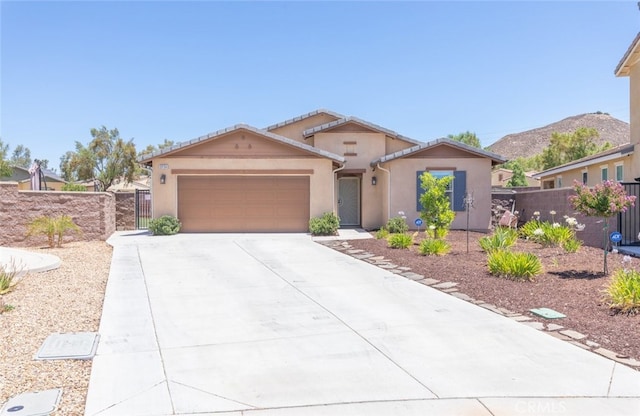 29184 Tree House, Lake Elsinore, CA 92530 - view of front facade with a garage, concrete driveway, stucco siding, and a gate