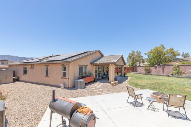 29184 Tree House, Lake Elsinore, CA 92530 - rear view of house with a fire pit, solar panels, a fenced backyard, a patio, and stucco siding