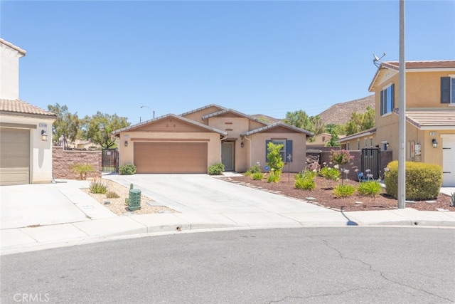 29184 Tree House, Lake Elsinore, CA 92530 - view of front of house featuring stucco siding, driveway, an attached garage, and a gate