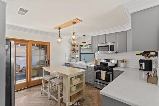 4332 Fairbrook Ln, Moorpark, CA 93021 - kitchen featuring stainless steel appliances, open shelves, gray cabinetry, light countertops, and crown molding