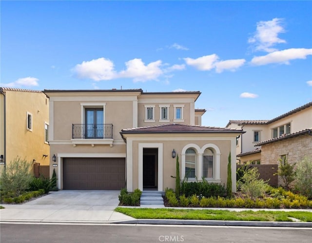 138 Jayhawk, Irvine, CA 92602 - view of front facade featuring a balcony, concrete driveway, a garage, stucco siding, and french doors