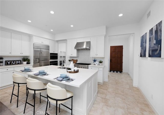 138 Jayhawk, Irvine, CA 92602 - kitchen with stainless steel built in fridge, exhaust hood, a center island with sink, recessed lighting, and light countertops