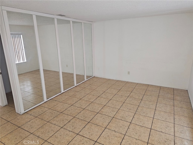 7941 Midhurst Dr, Highland, CA 92346 - unfurnished bedroom featuring a textured ceiling and light tile patterned floors