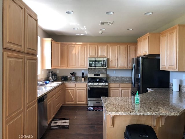 707 Joseph Pl, Isleton, CA 95641 - kitchen featuring appliances with stainless steel finishes, light brown cabinets, a peninsula, dark wood-style floors, and a breakfast bar