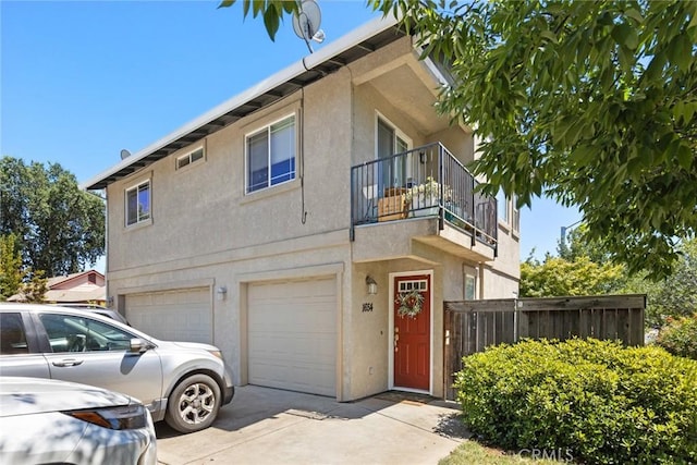 1654 E Ave, Chico, CA 95926 - view of front facade with a garage, driveway, a balcony, and stucco siding