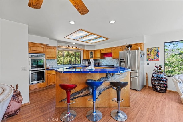 1104 Snowbird Dr, Frazier Park, CA 93225 - kitchen with appliances with stainless steel finishes, dark countertops, a kitchen island, decorative backsplash, and recessed lighting