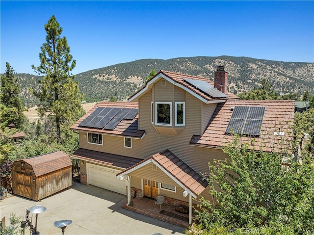 1104 Snowbird Dr, Frazier Park, CA 93225 - traditional-style home featuring roof mounted solar panels, a mountain view, a storage shed, a chimney, and concrete driveway