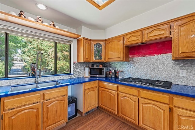 1104 Snowbird Dr, Frazier Park, CA 93225 - kitchen with appliances with stainless steel finishes, light wood finished floors, brown cabinets, tasteful backsplash, and dark countertops