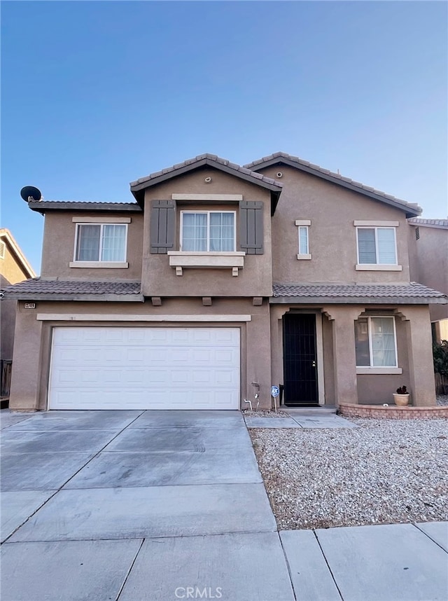 13749 Starshine Dr, Victorville, CA 92392 - view of front of home with stucco siding, a garage, a tiled roof, and driveway