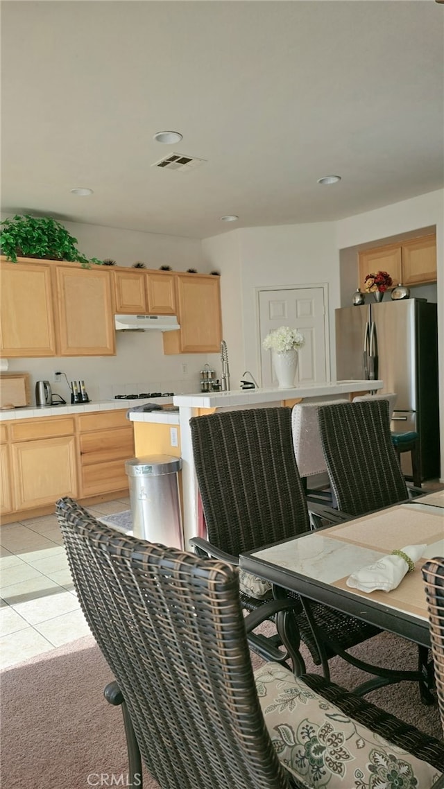 13749 Starshine Dr, Victorville, CA 92392 - kitchen with under cabinet range hood, light brown cabinetry, freestanding refrigerator, light countertops, and recessed lighting