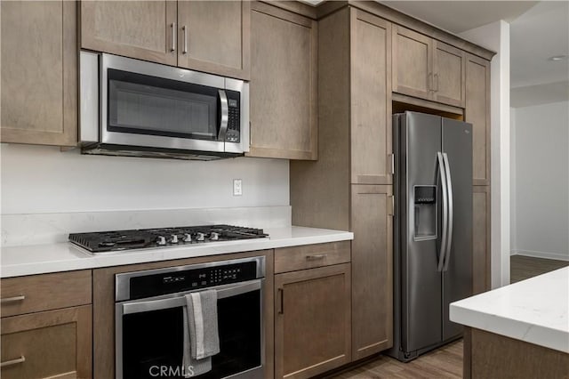 29526 Woodcreek Trl, Winchester, CA 92596 - kitchen featuring appliances with stainless steel finishes, light countertops, and light wood-style flooring