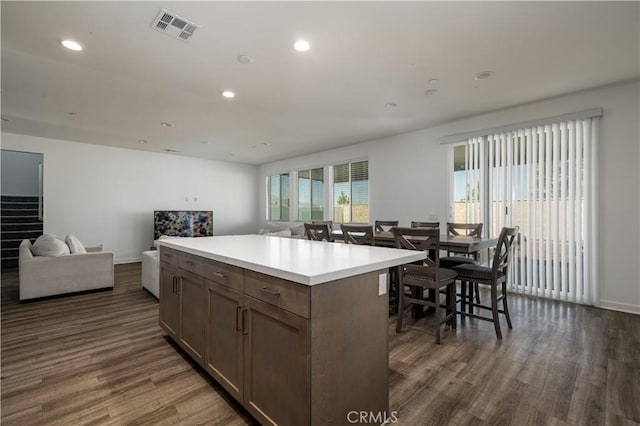 29526 Woodcreek Trl, Winchester, CA 92596 - kitchen with dark wood-type flooring, open floor plan, light countertops, a kitchen island, and recessed lighting