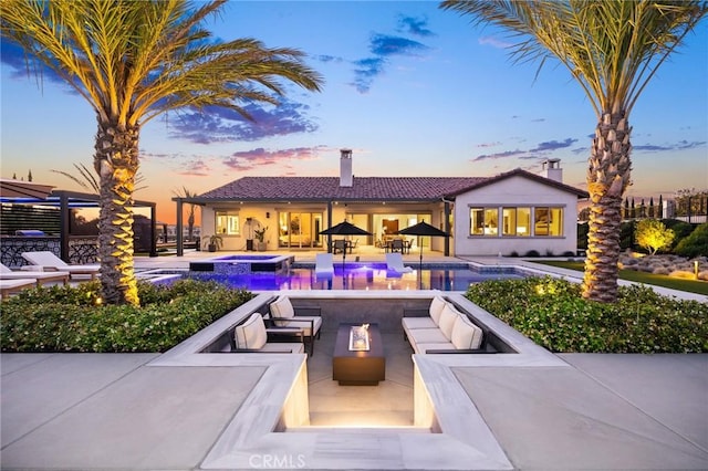 41783 Valencia Way, Temecula, CA 92592 - pool at dusk featuring an outdoor living space with a fire pit, a patio area, and a pool with connected hot tub
