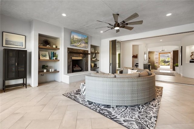 41783 Valencia Way, Temecula, CA 92592 - living area with built in shelves, ceiling fan, a fireplace with raised hearth, and recessed lighting