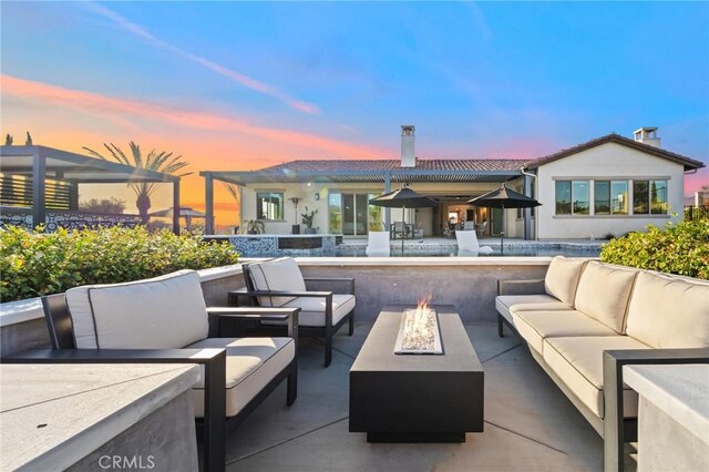 41783 Valencia Way, Temecula, CA 92592 - patio terrace at dusk with an outdoor living space with a fire pit and a patio area