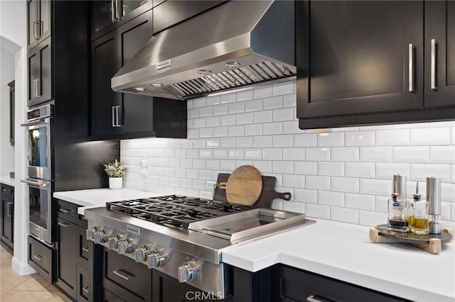 41783 Valencia Way, Temecula, CA 92592 - kitchen with exhaust hood, appliances with stainless steel finishes, backsplash, light countertops, and dark cabinetry