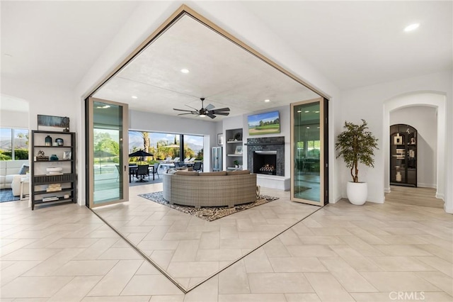 41783 Valencia Way, Temecula, CA 92592 - living area with a ceiling fan, plenty of natural light, a fireplace with raised hearth, arched walkways, and recessed lighting