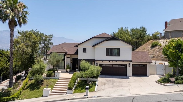 2056 Dublin Dr, Glendale, CA 91206 - view of front facade with concrete driveway, stucco siding, a gate, a mountain view, and an attached garage