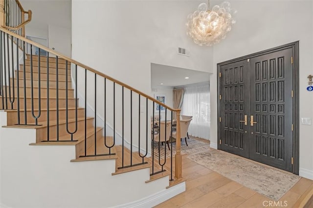 2056 Dublin Dr, Glendale, CA 91206 - entryway with wood-type flooring, stairs, a chandelier, and a towering ceiling