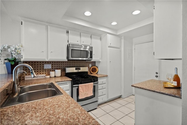1495 Mccabe Way, West Covina, CA 91791 - kitchen with stainless steel appliances, a raised ceiling, white cabinetry, decorative backsplash, and recessed lighting