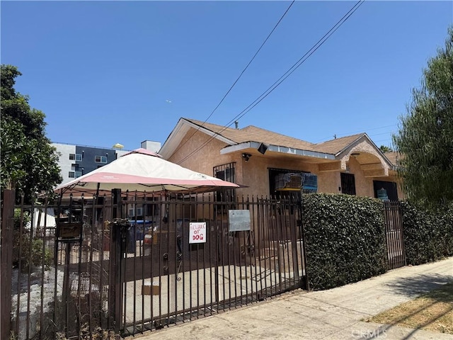 1569 E 109th St, Los Angeles, CA 90059 - view of front facade with a fenced front yard, stucco siding, and a gate