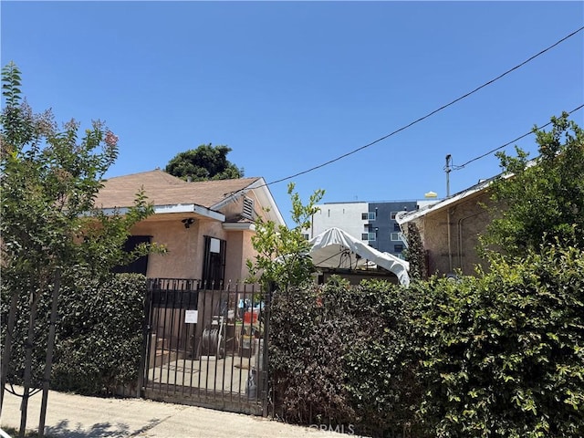 1569 E 109th St, Los Angeles, CA 90059 - view of home's exterior with a fenced front yard, a gate, and stucco siding