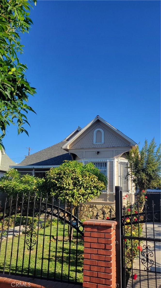 207 E 25th St, Los Angeles, CA 90011 - view of side of property with a gate and roof with shingles