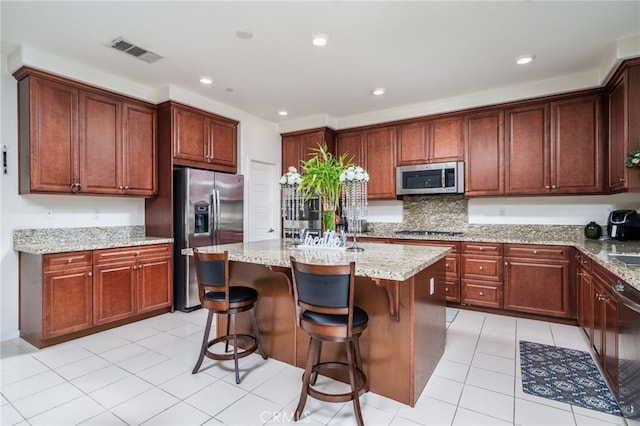 13243 Stanton Dr, Rancho Cucamonga, CA 91739 - kitchen with stainless steel appliances, a center island, light stone countertops, a breakfast bar, and recessed lighting