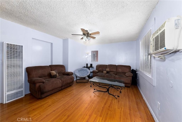 1684 E Martin Luther King Jr Blvd, Los Angeles, CA 90011 - living room with a heating unit, light wood-style flooring, a ceiling fan, a textured ceiling, and a wall unit AC