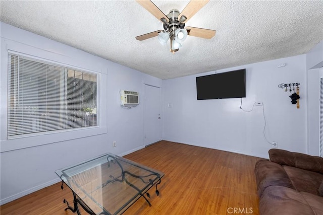 1684 E Martin Luther King Jr Blvd, Los Angeles, CA 90011 - unfurnished living room featuring a textured ceiling, an AC wall unit, a ceiling fan, and wood finished floors