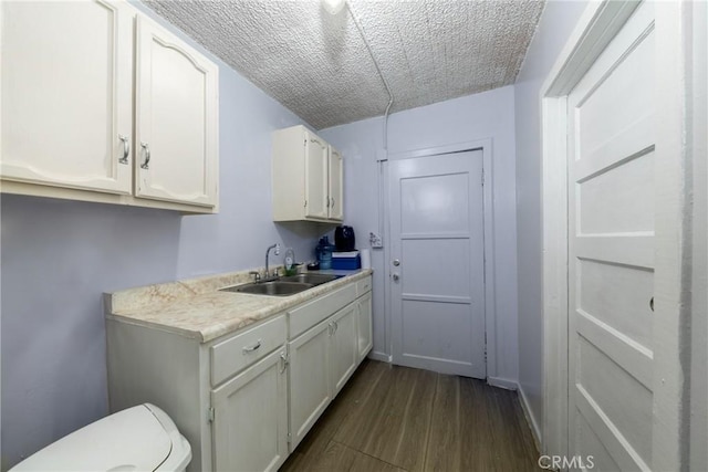 1684 E Martin Luther King Jr Blvd, Los Angeles, CA 90011 - washroom featuring dark wood-type flooring and a textured ceiling