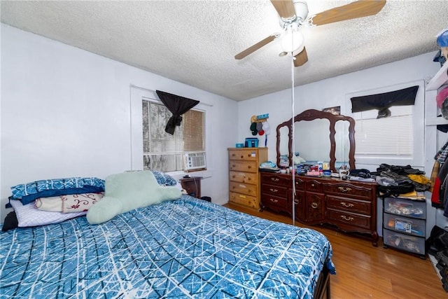 1684 E Martin Luther King Jr Blvd, Los Angeles, CA 90011 - bedroom featuring a textured ceiling, wood finished floors, ceiling fan, and cooling unit