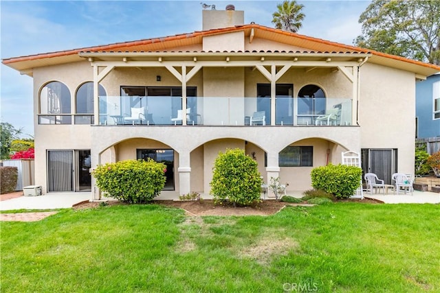 750 Luisita St, Morro Bay, CA 93442 - rear view of house featuring a balcony, a chimney, stucco siding, and a lawn