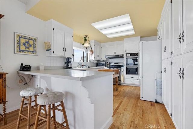 750 Luisita St, Morro Bay, CA 93442 - kitchen with stainless steel appliances, under cabinet range hood, a peninsula, and backsplash