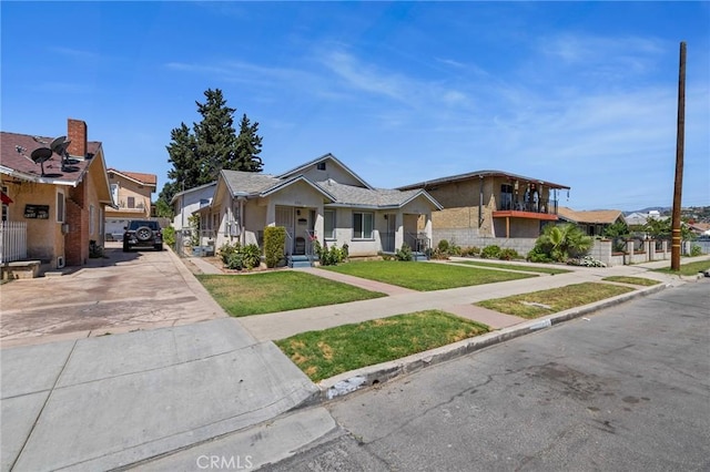 228 S 4th St, Santa Paula, CA 93060 - view of front of house with driveway, a front yard, a residential view, and stucco siding