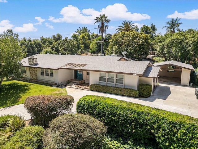1296 Tiger Tail Dr, Riverside, CA 92506 - view of front of house featuring a front yard, driveway, a detached carport, stucco siding, and stone siding