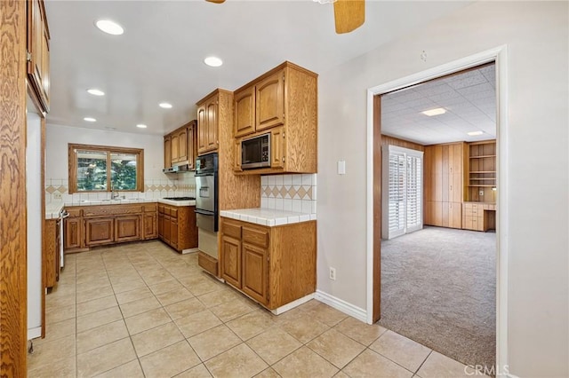 1296 Tiger Tail Dr, Riverside, CA 92506 - kitchen with oven, brown cabinets, light tile patterned floors, recessed lighting, and light colored carpet