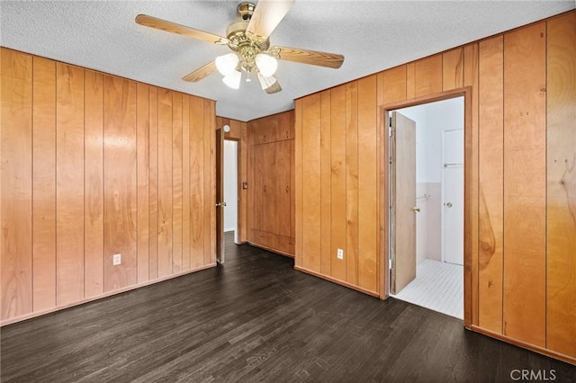 1296 Tiger Tail Dr, Riverside, CA 92506 - empty room featuring dark wood finished floors, wood walls, a ceiling fan, and a textured ceiling