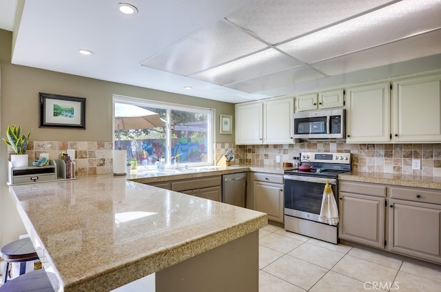23402 Devonshire Dr, Lake Forest, CA 92630 - kitchen with stainless steel appliances, a peninsula, tile counters, backsplash, and a breakfast bar area