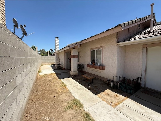 5320 Jonah St, Bakersfield, CA 93307 - view of side of property featuring stucco siding, a tiled roof, and a fenced backyard