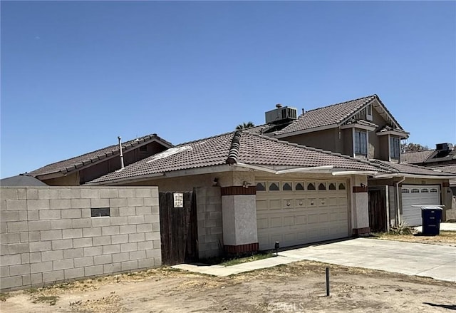 5320 Jonah St, Bakersfield, CA 93307 - view of front of property with an attached garage, driveway, a tile roof, and stucco siding