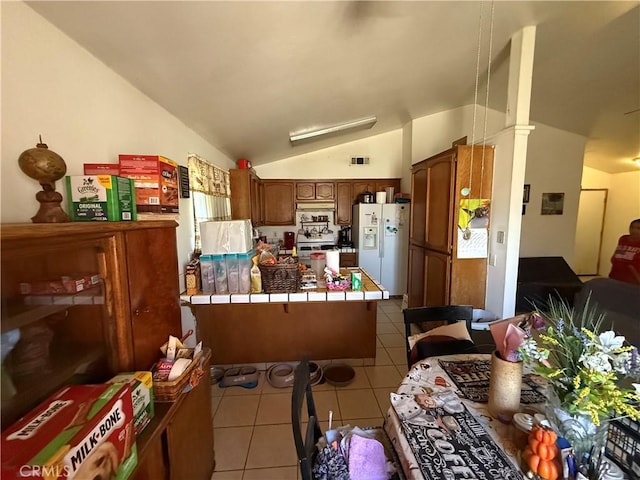 5320 Jonah St, Bakersfield, CA 93307 - kitchen featuring tile countertops, white fridge with ice dispenser, a peninsula, lofted ceiling, and light tile patterned floors