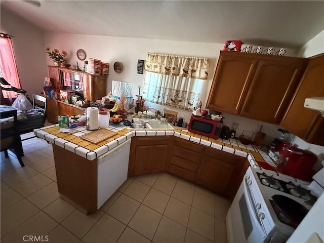5320 Jonah St, Bakersfield, CA 93307 - kitchen with a peninsula, light tile patterned floors, exhaust hood, tile countertops, and white gas range