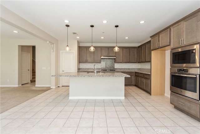 16123 Apricot Ave, Chino, CA 91708 - kitchen featuring appliances with stainless steel finishes, decorative backsplash, under cabinet range hood, light stone countertops, and decorative light fixtures